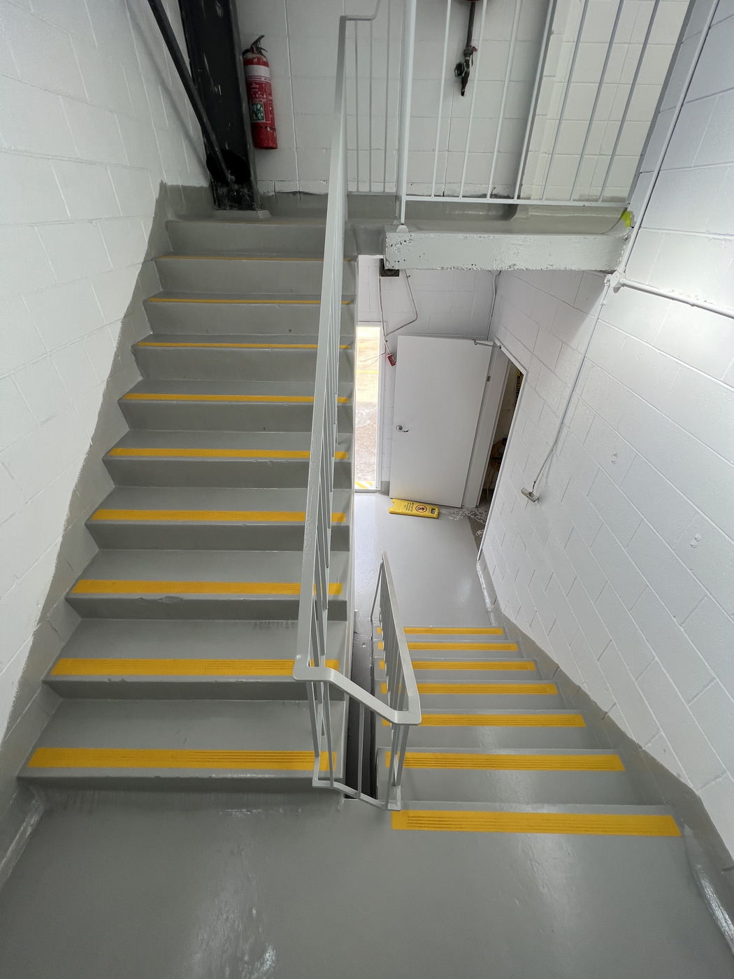 Industrial staircase with yellow anti slip safety strips